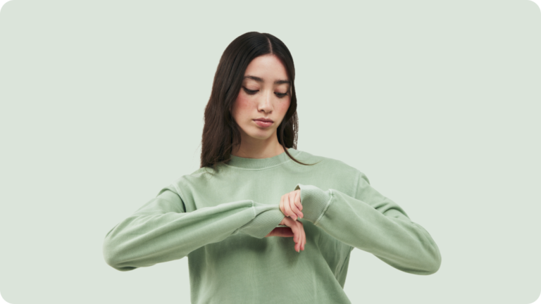 Woman wearing organic cotton sweatshirt and examining material